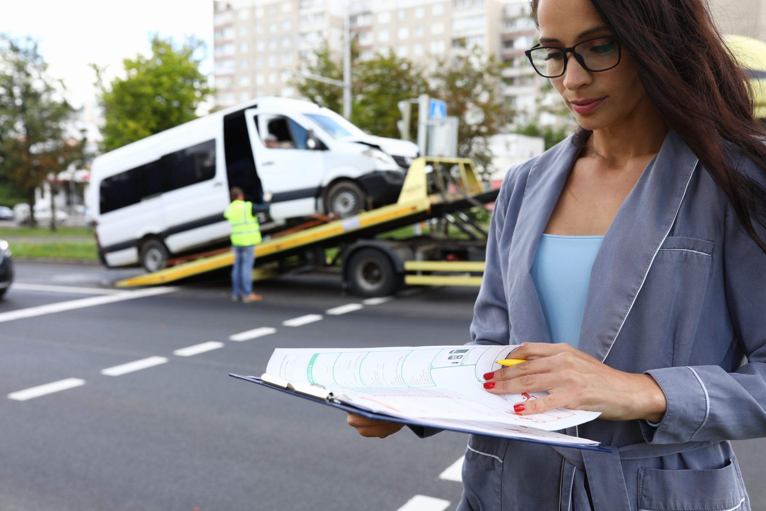 Female agent fills out insurance at the scene of accident. Eine Frau dokumentiert einen Schaden an ihrem Auto für die Versicherung